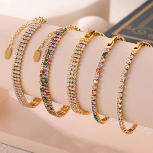 Elegant tennis bracelets displayed on a jewelry stand, emphasizing the gold finish and zirconia details.