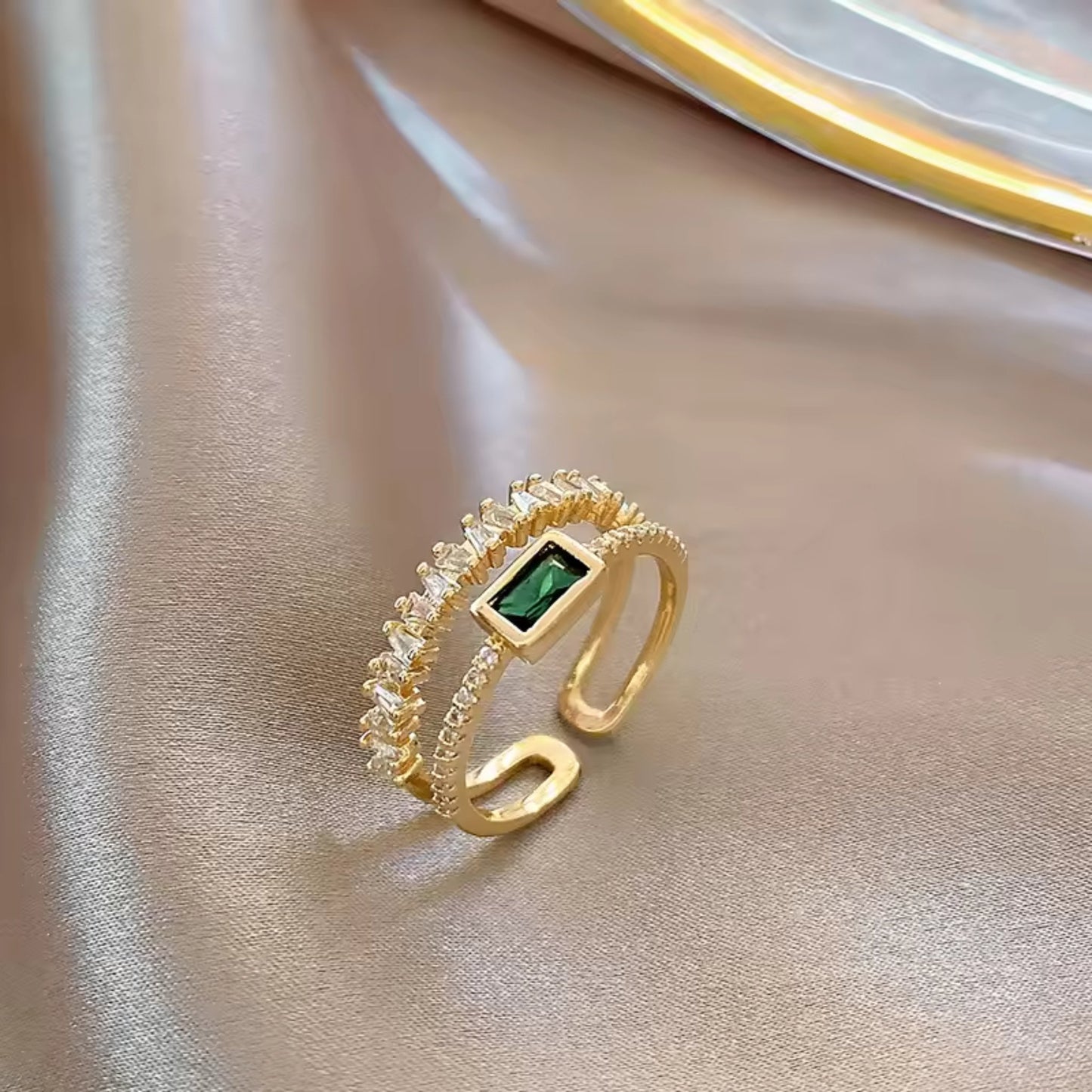 Side view of the Emerald Radiance Adjustable Ring, highlighting the green rectangular zircon and gold-plated band with crystal accents.