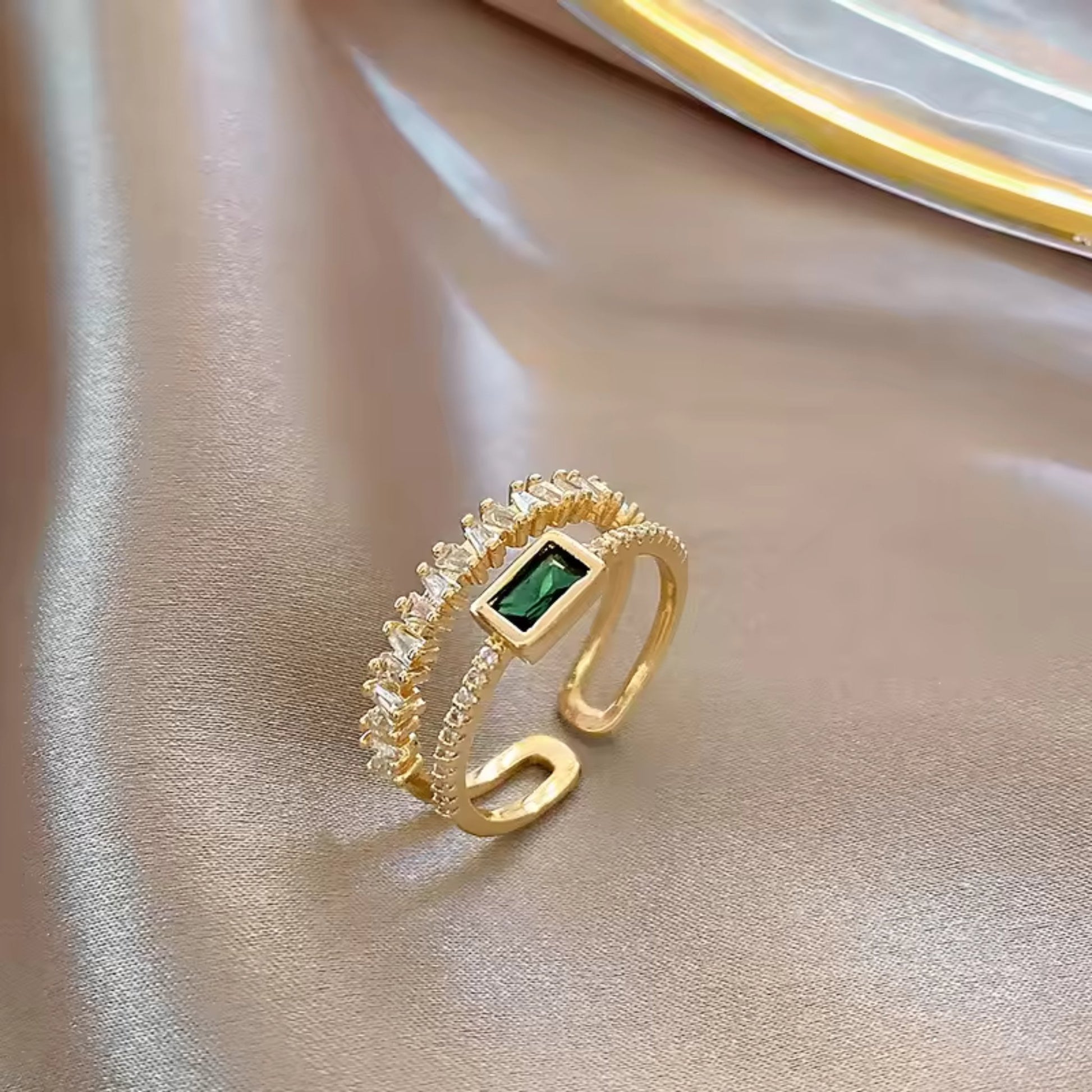 Side view of the Emerald Radiance Adjustable Ring, highlighting the green rectangular zircon and gold-plated band with crystal accents.