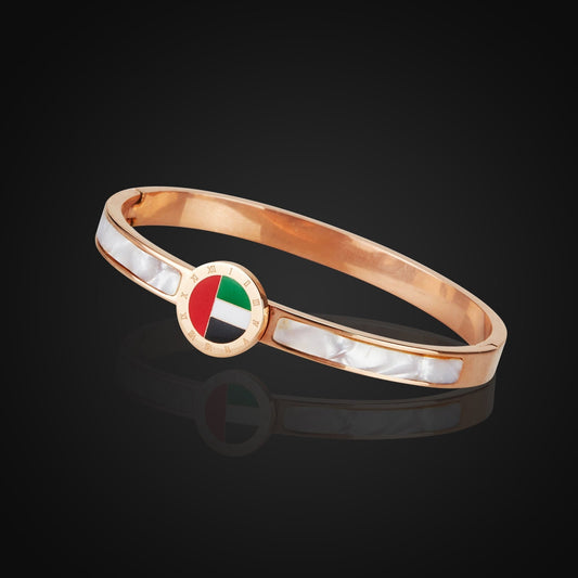 Emirates Pride Bangle featuring a round UAE flag charm and 18K rose gold plating, displayed on a Black background.
