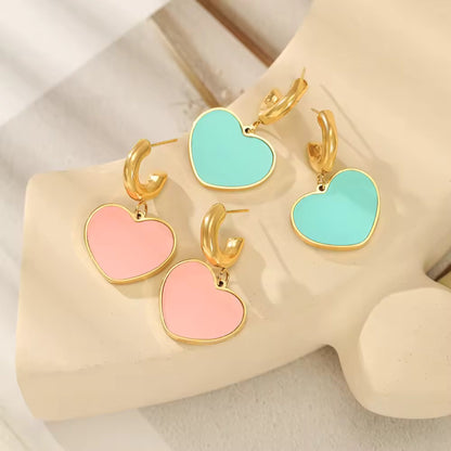 Detailed view of Enamel Heart Hoop Earrings, showcasing gold-tone hoops with vibrant Baby Pink and Light Green enamel heart pendants.