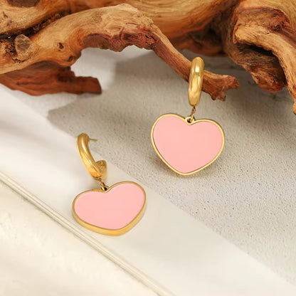 Detailed view of Enamel Heart Hoop Earrings, showcasing gold-tone hoops with vibrant Baby Pink enamel heart pendants.