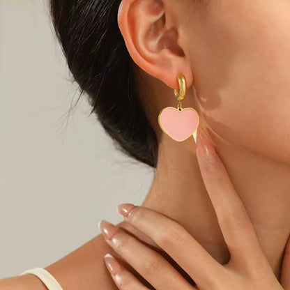 Model wearing Enamel Heart Hoop Earrings in Light Pink, highlighting the chic and playful design.