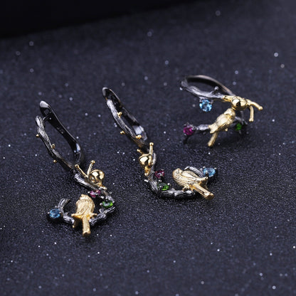 Detailed view of Swiss Blue Topaz, amethyst, and peridot stones on 925 Sterling Silver Bird & Snail Earrings with black gun and gold plating.