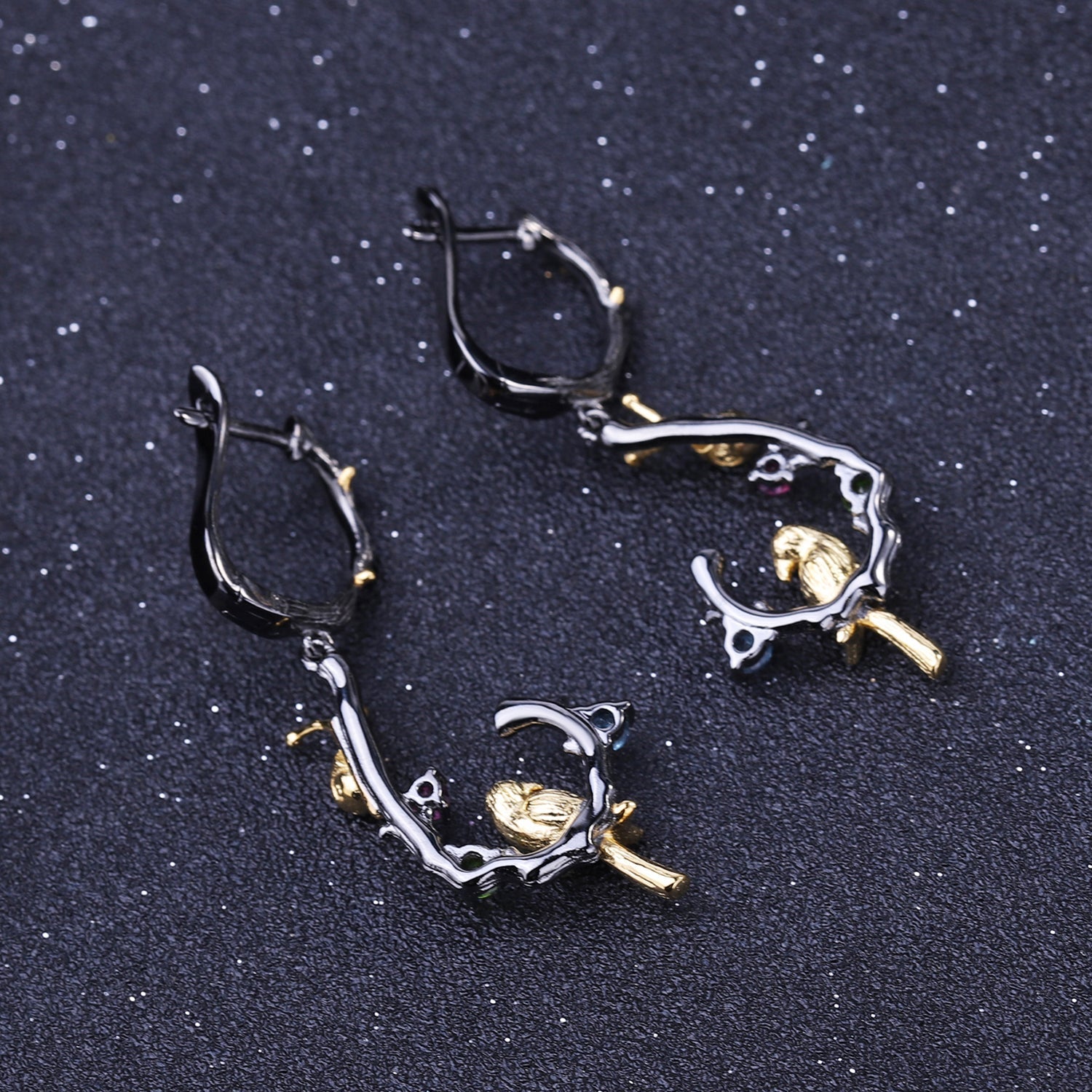 Detailed view of Swiss Blue Topaz, amethyst, and peridot stones on 925 Sterling Silver Bird & Snail Earrings with black gun and gold plating.