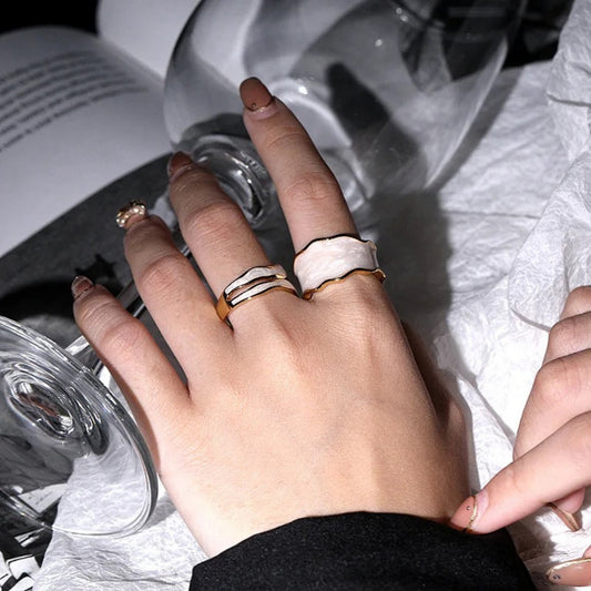 Model styling the Enchanted Wave Rings, displaying the adjustable fit and vibrant enamel colors paired with elegant attire.