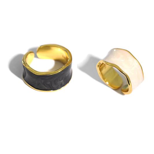 Set of Enchanted Wave Adjustable Rings in White, Purple, Dark Blue, and Dark Gray enamel, showcasing their elegant wave design and 18K gold-plated finish.