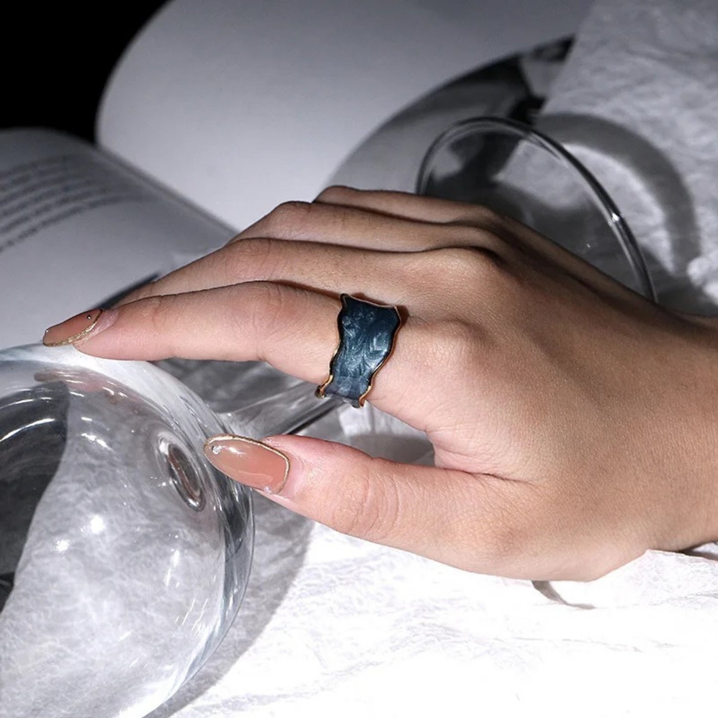 Model styling the Enchanted Wave Rings, displaying the adjustable fit and vibrant enamel colors paired with elegant attire.