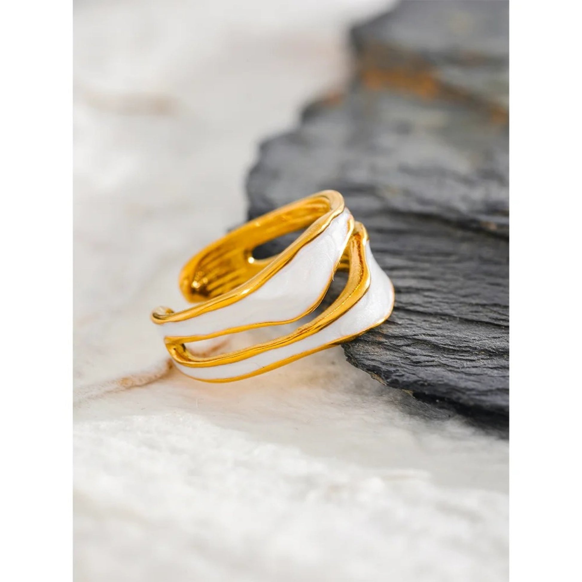 Detailed view of the Enchanted Waves Open Ring showcasing the creative irregular design, glossy white enamel, and luxurious gold plating.