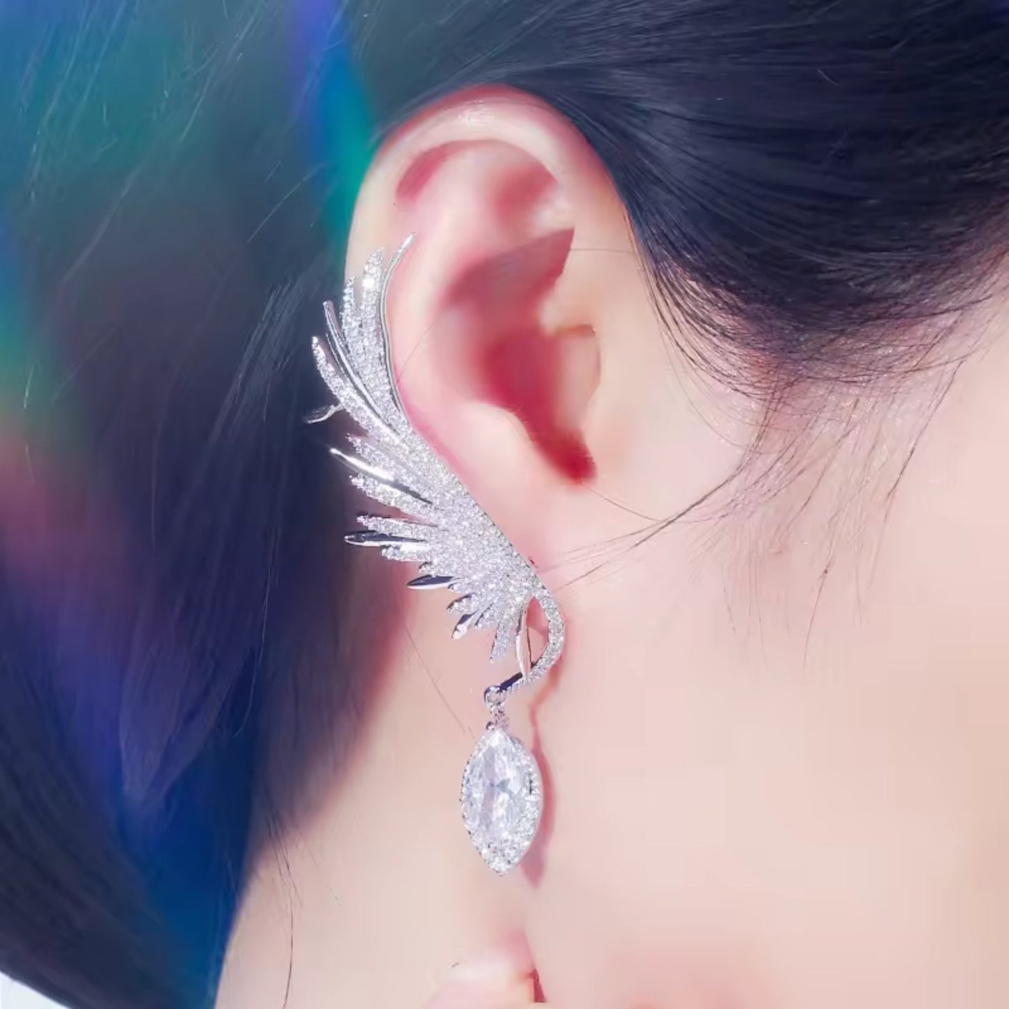 Model wearing Enchanted Wings Feather Drop Earrings, with white zircons cascading along the ear in an elegant climber and drop style.