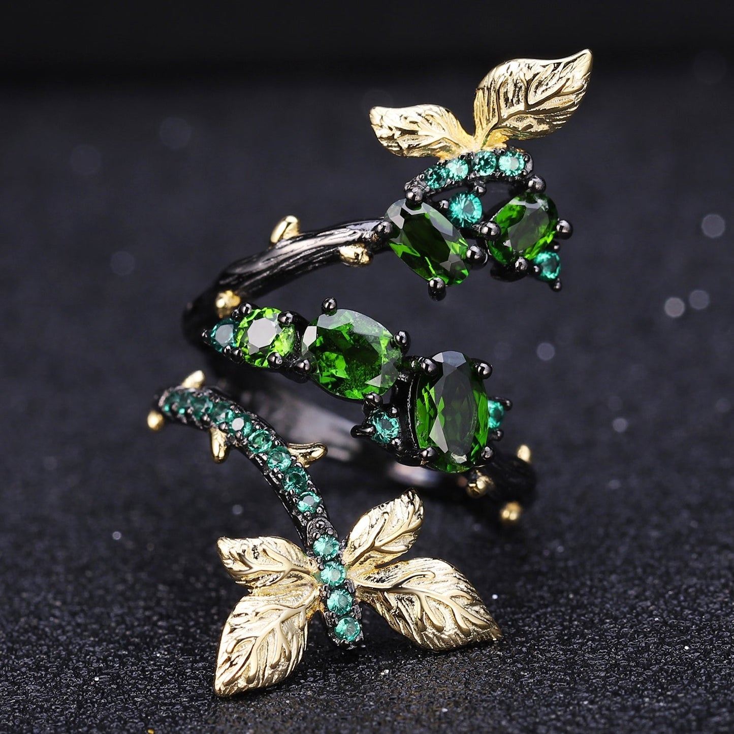 Enchanting Leaves Ring with intricate golden leaf motifs and a sleek black gun-plated finish, highlighting the rich green Chrome Diopside centerpiece.