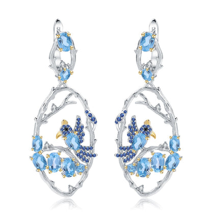 Flat lay of the Ethereal Swiss Blue Topaz Branch Earrings on a white background, emphasizing their elegant design and shimmering blue stones.