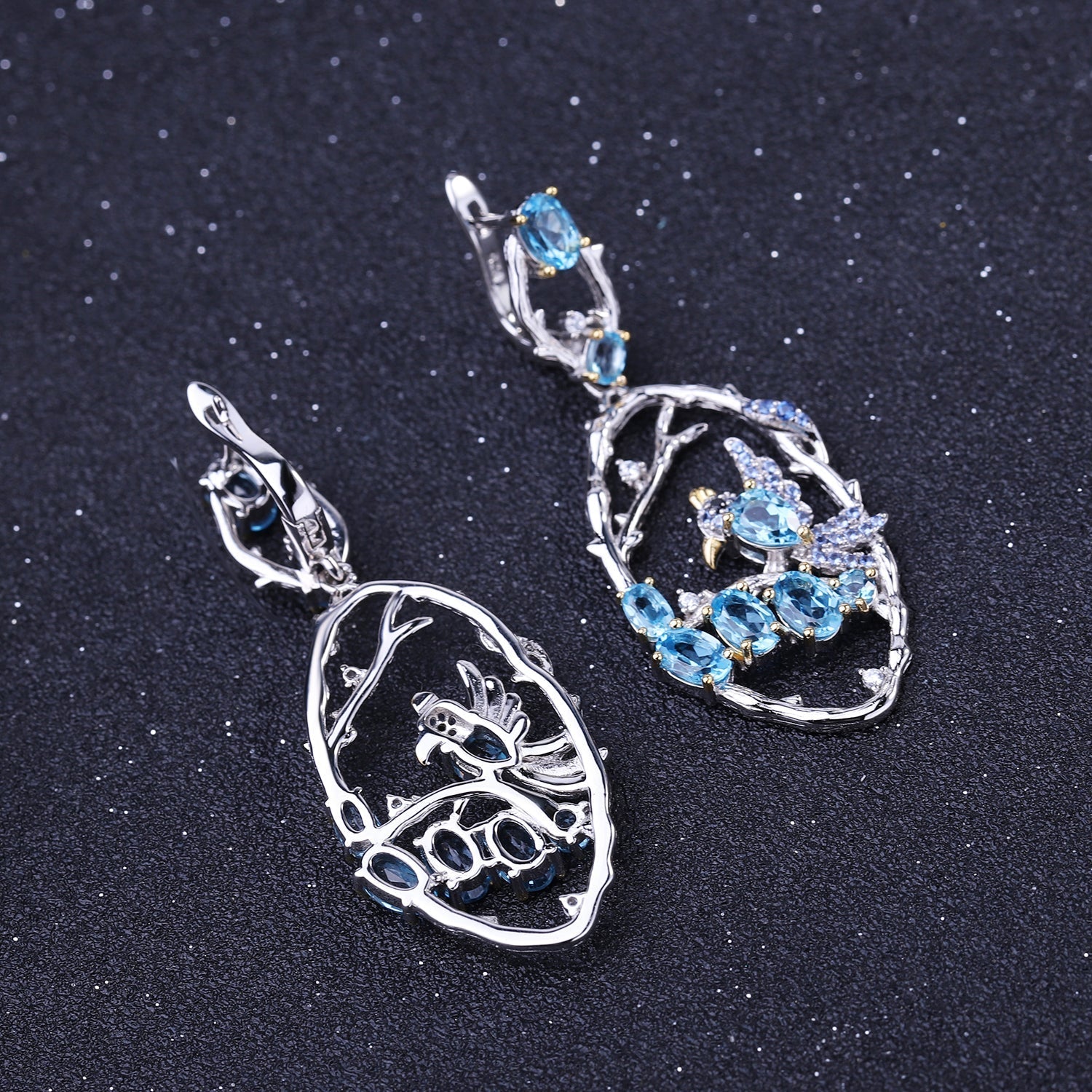 Close-up of Ethereal Swiss Blue Topaz Branch Earrings, featuring natural blue topaz stones set in intricate 925 sterling silver with gold and rhodium plating.
