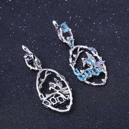 Close-up of Ethereal Swiss Blue Topaz Branch Earrings, featuring natural blue topaz stones set in intricate 925 sterling silver with gold and rhodium plating.