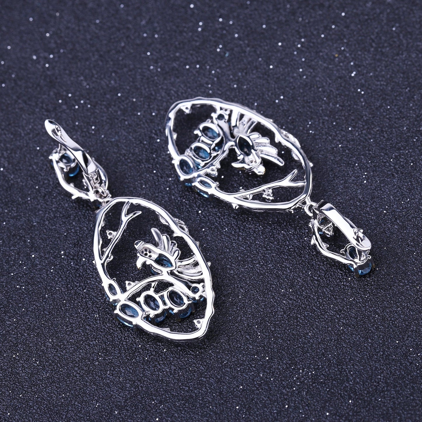 Close-up of Ethereal Swiss Blue Topaz Branch Earrings, featuring natural blue topaz stones set in intricate 925 sterling silver with gold and rhodium plating.