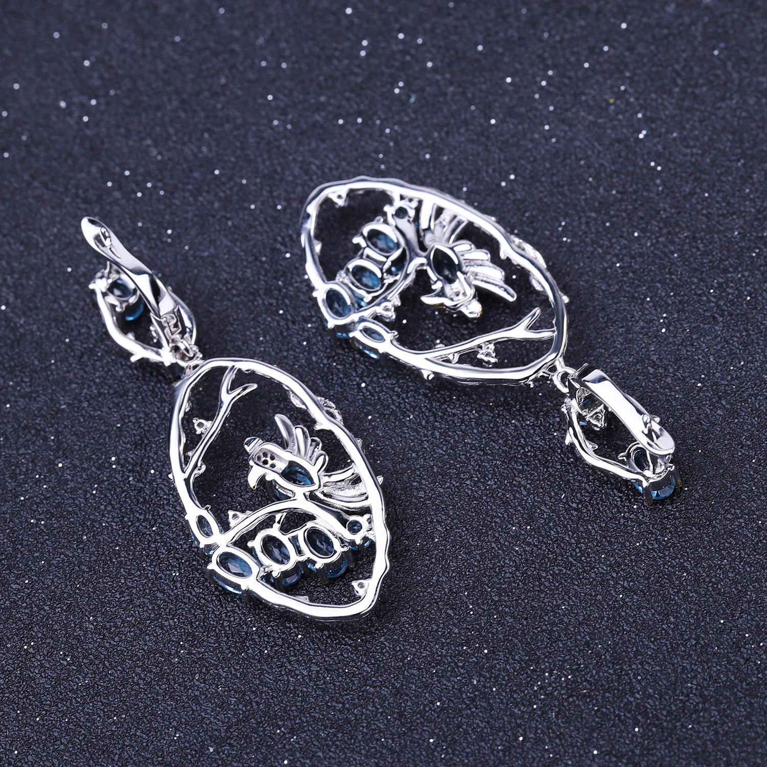Close-up of Ethereal Swiss Blue Topaz Branch Earrings, featuring natural blue topaz stones set in intricate 925 sterling silver with gold and rhodium plating.