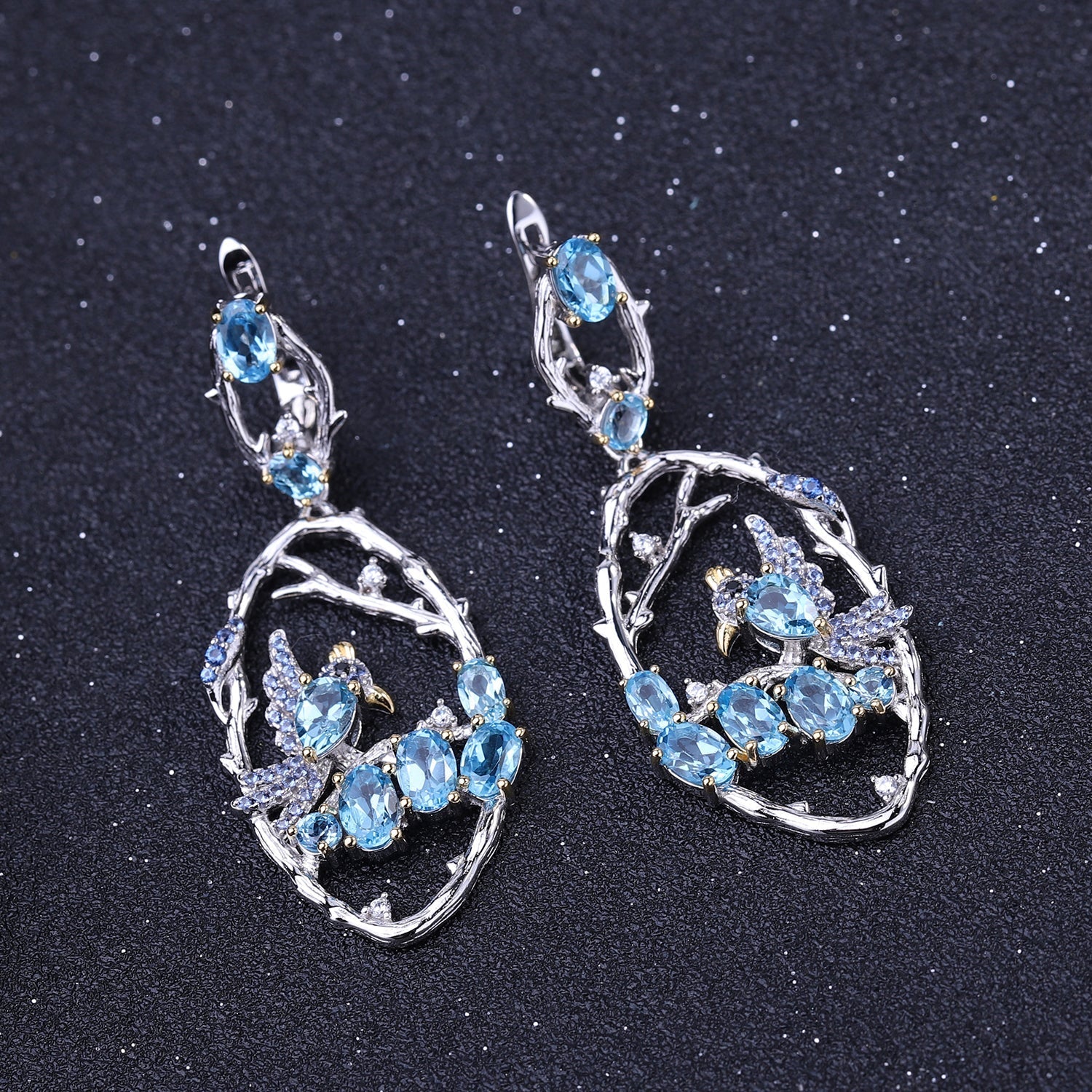 Close-up of Ethereal Swiss Blue Topaz Branch Earrings, featuring natural blue topaz stones set in intricate 925 sterling silver with gold and rhodium plating.