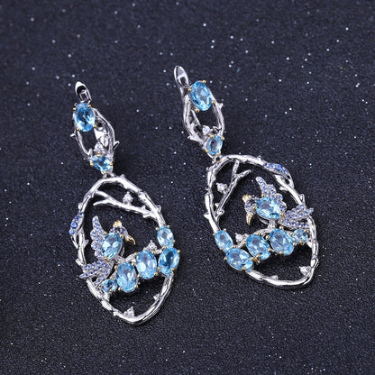 Close-up of Ethereal Swiss Blue Topaz Branch Earrings, featuring natural blue topaz stones set in intricate 925 sterling silver with gold and rhodium plating.