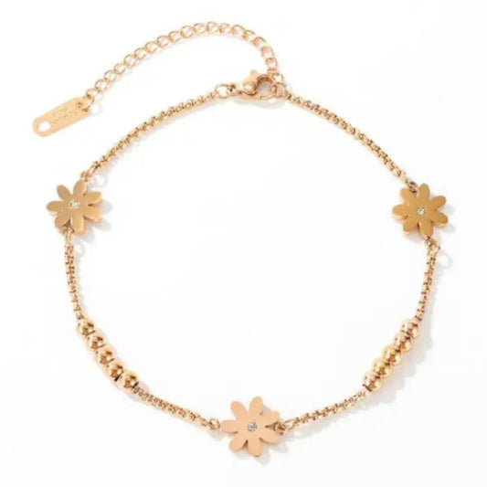 Floral Charm 18K Rose Gold Plated Anklet laid flat on a white background, highlighting its design and adjustable chain.