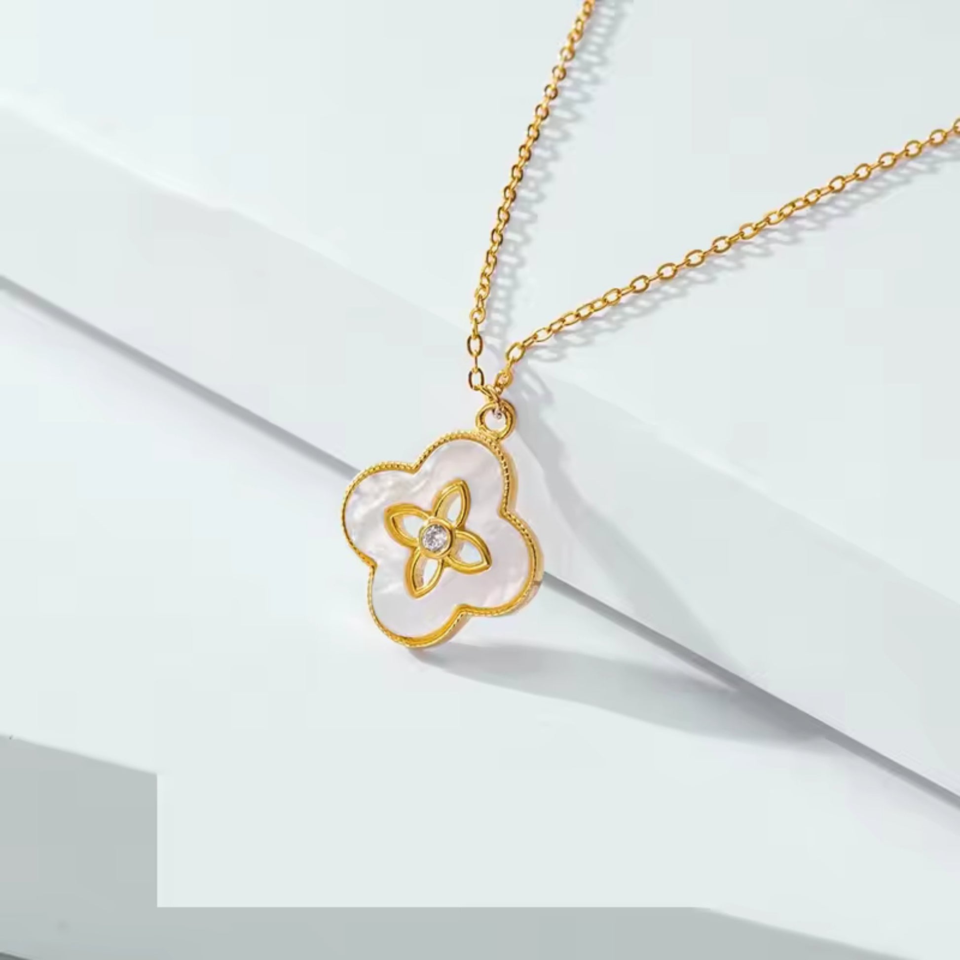 Close-up of the Floral Radiance Pendant Necklace, showing the mother of pearl floral design and sparkling center crystal on an 18K gold-plated chain.