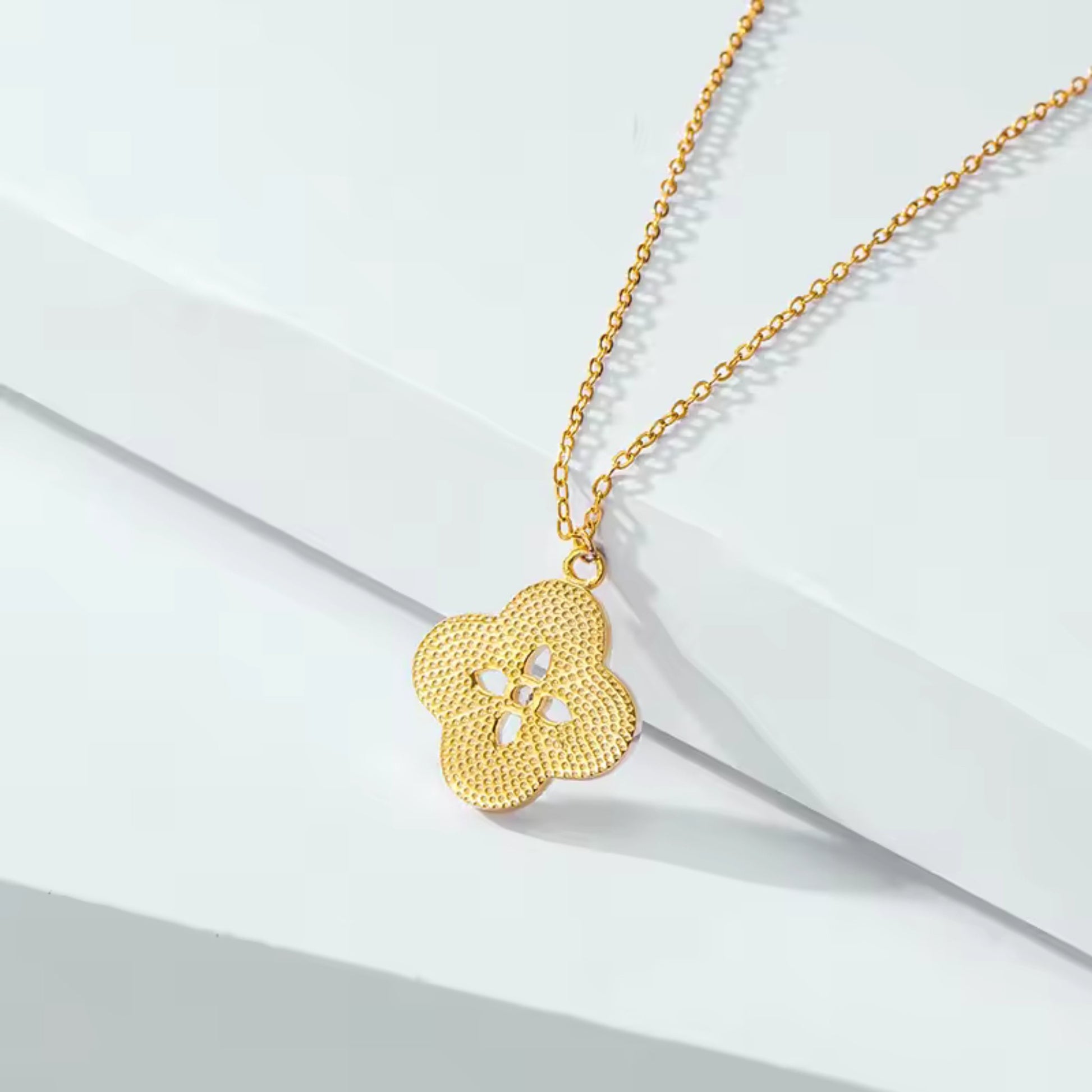 Close-up of the back Floral Radiance Pendant Necklace, showing the mother of pearl floral design and sparkling center crystal on an 18K gold-plated chain.